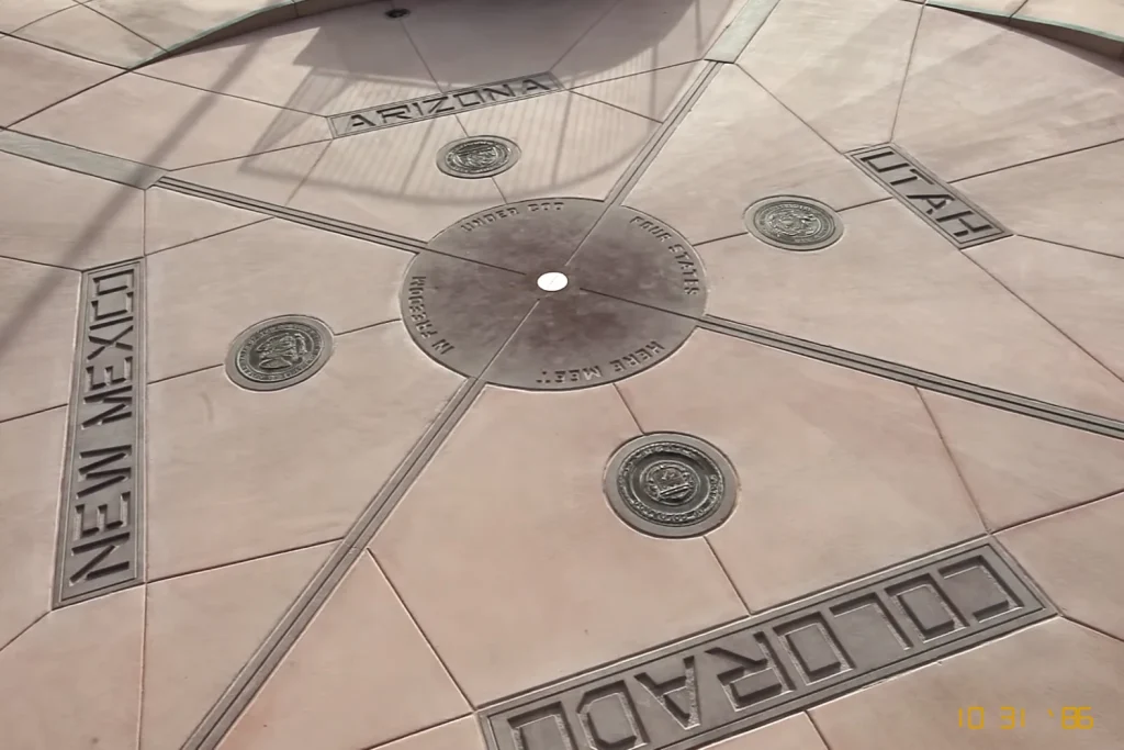 18 Cool 40th Birthday Travel Ideas (with Friends & Family) 12 A circular monument marks the intersection of four U.S. states: Arizona, Utah, Colorado, and New Mexico. Each state's name and seal are engraved on the ground, radiating from a central point where the states converge. Visit the Four Corners to see the date 10-31-96 visible in the corner.